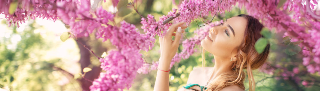 ピンクの花に顔を近づける女性